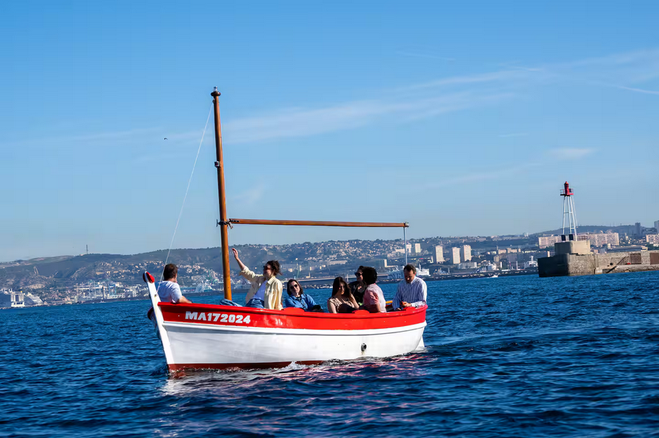 Des voyageurs en visite des calanques à bord d'un bateau traditionnel